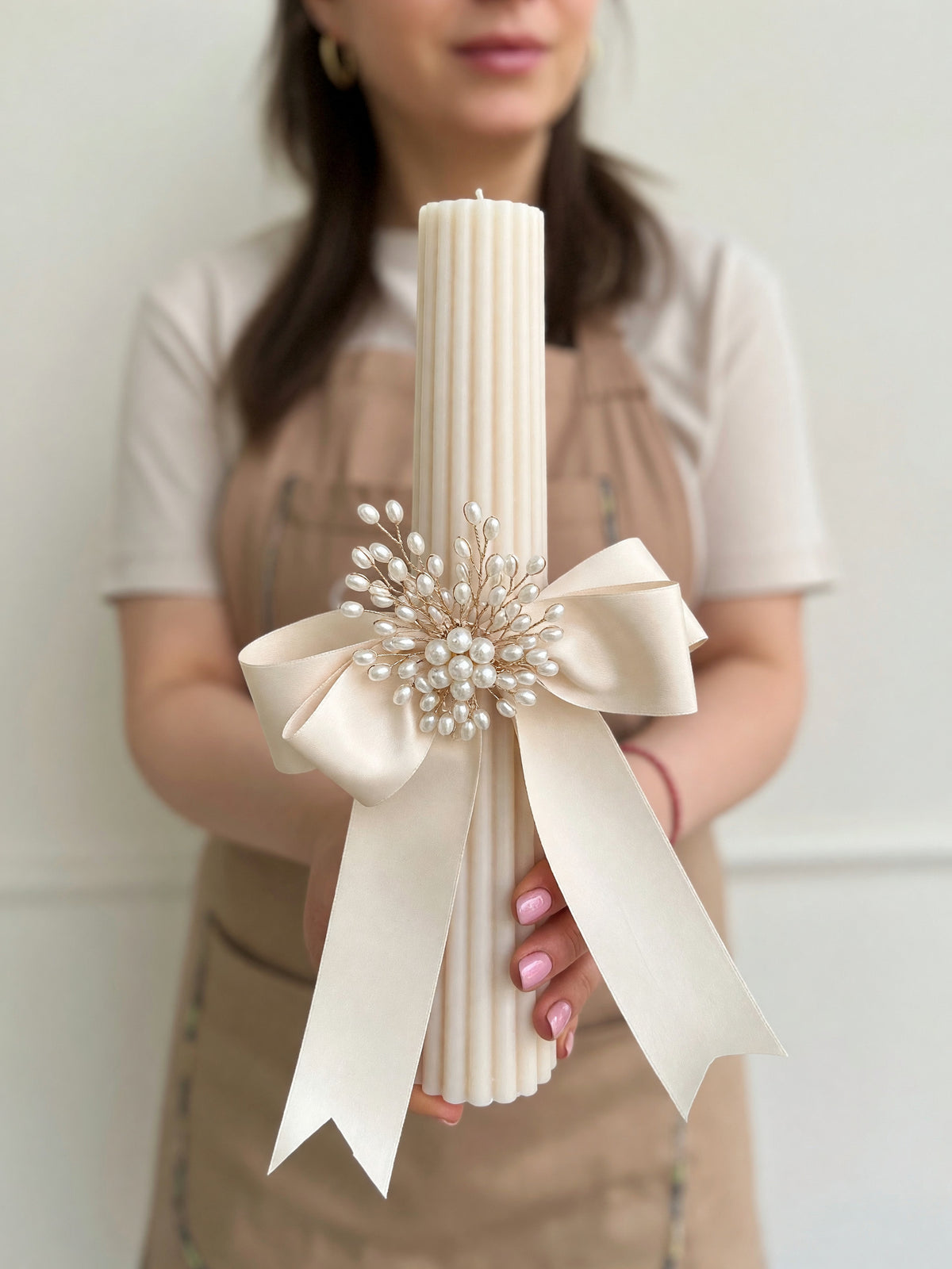 Lumânare conică bej de 27 cm, decorată cu perle și fundă din satin crem